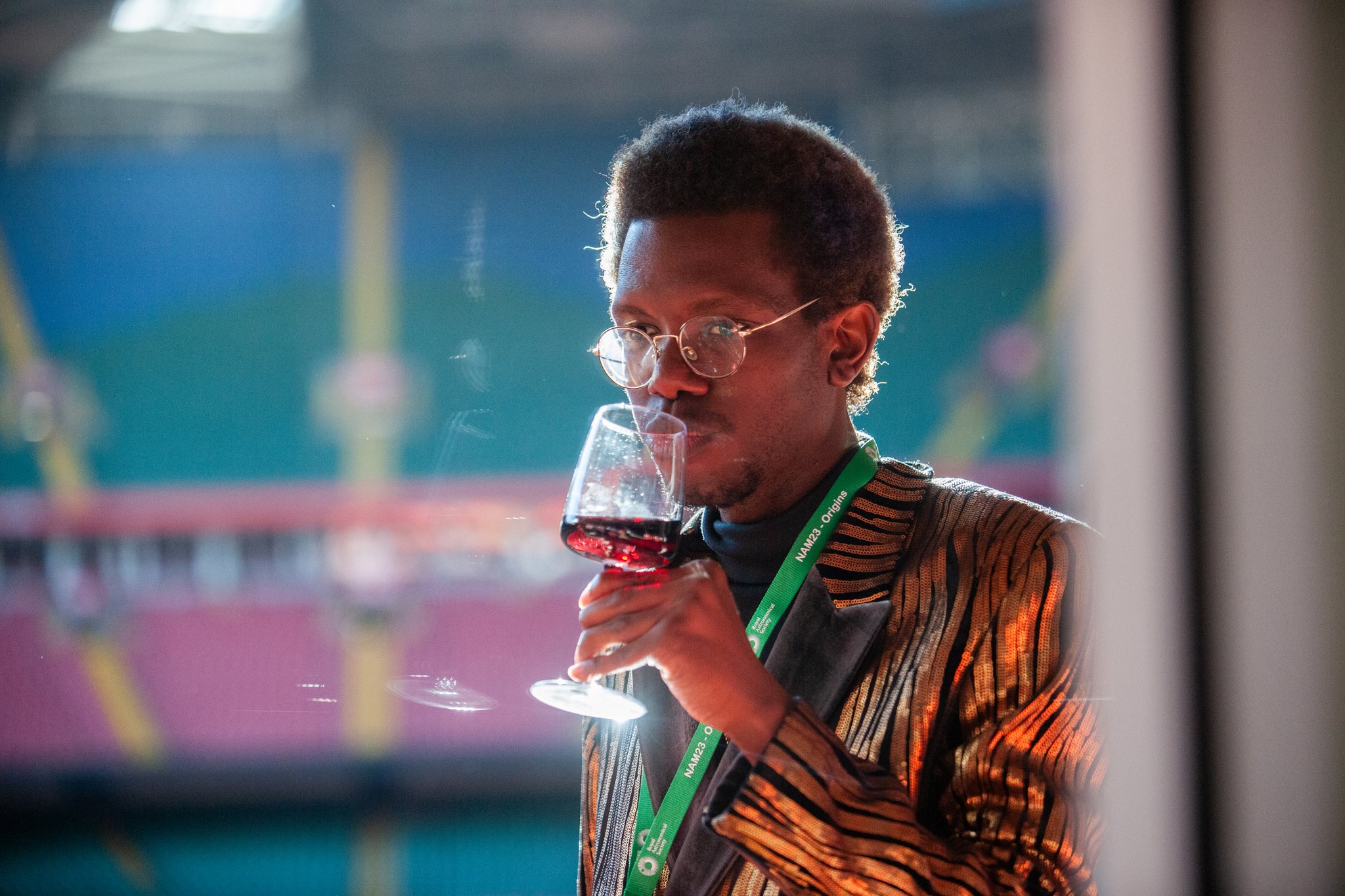 KeShawn drinking a glass of wine at the Royal Astronomical Society 2023 meeting.
